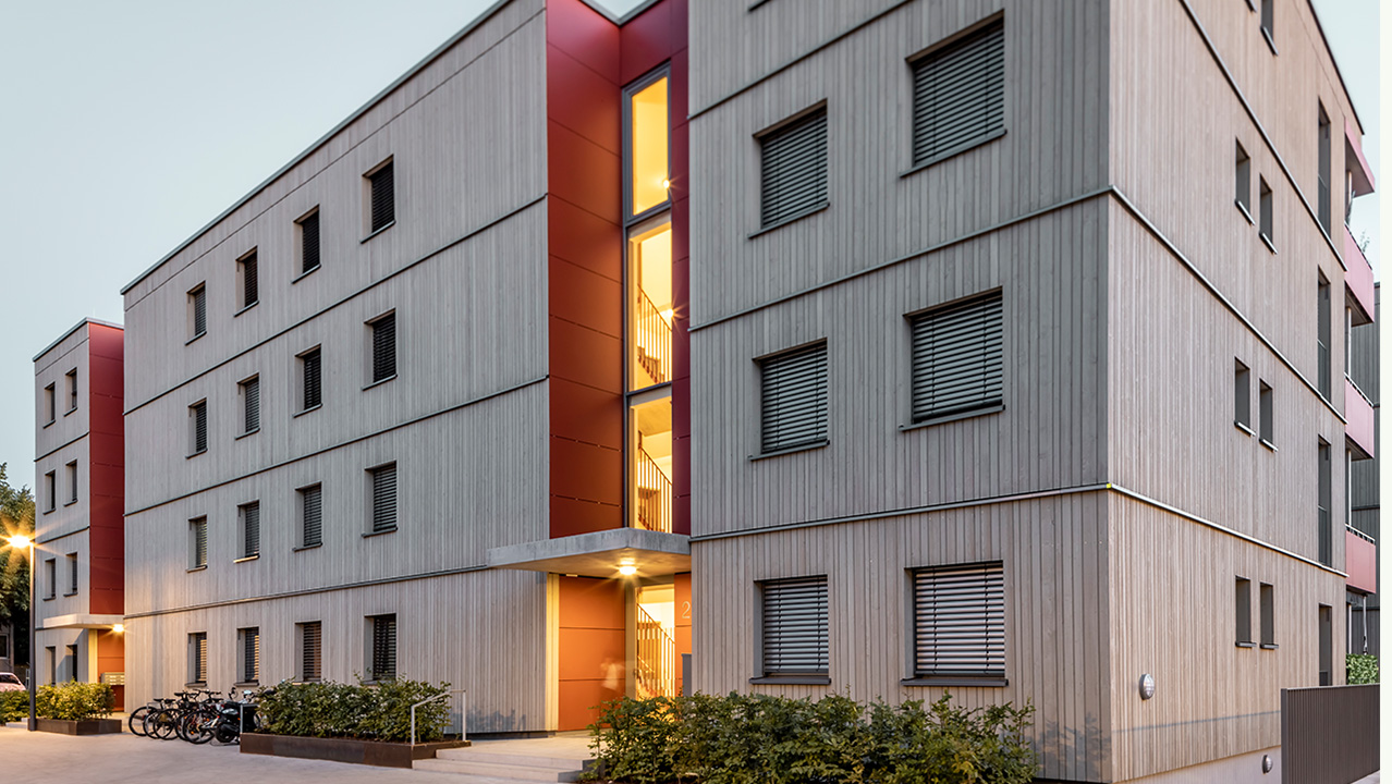 Das bild zeigt ein Gebäude im Holzbau in der Abendstimmung